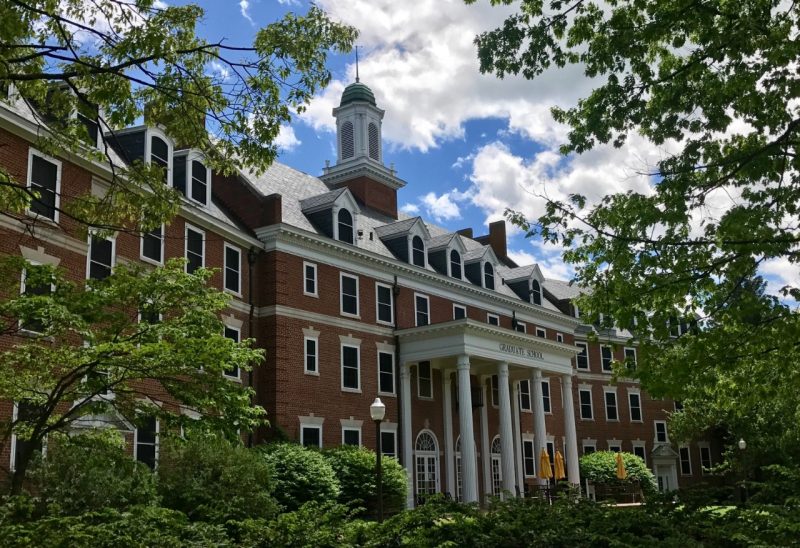 photo of the Alumni Hall GLC entrance as seen through trees in the spring